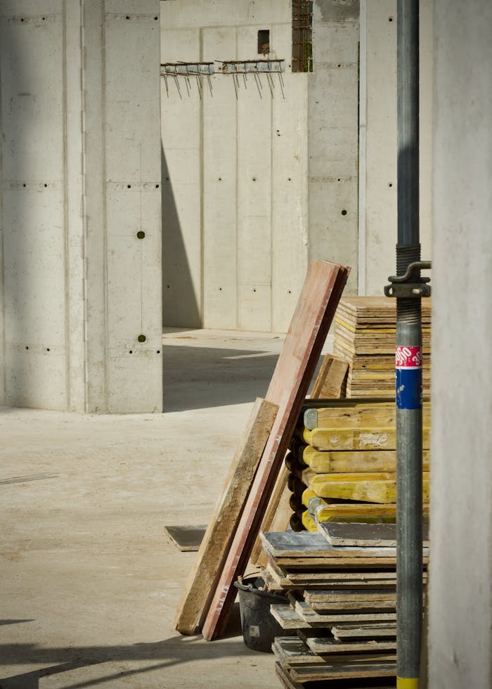 Concrete industrial site with stacked building materials and structure in progress.